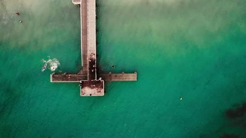 Aerial View of People Enjoying a Sunny Day on the Dock at a Tropical Seaside