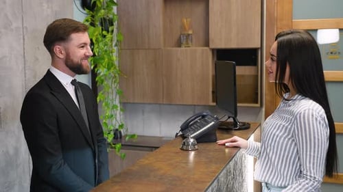 Businessman Checking in at Hotel Reception Desk