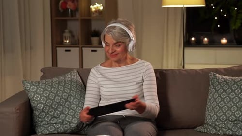 Technology, People and Lifestyle Concept - Happy Senior Woman in Headphones And