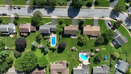 Noble american area with single family homes and turquoise Swimming pool in garden. Sunny day in sum