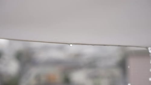 Close Up Of Rainwater Dripping Off An Open Parasol On A Rainy Weather. slow motion