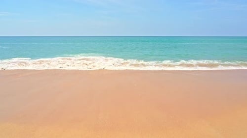 Amazing shot of waves crashing on golden beach. Slow-motion