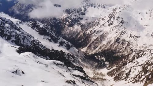 Aerial panoramic view of valley of Dolomite mountains covered with snow. Italy