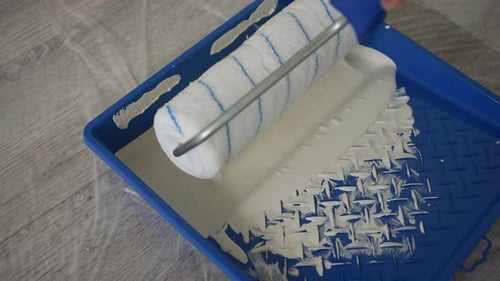 Painter Using Roller in Paint Tray Indoors