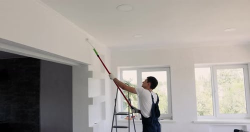Man Painting Wall in White Color with Roller