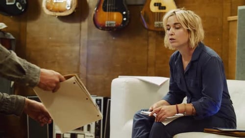 Une femme lit un carnet au ralenti dans un studio d'enregistrement de musique au Canada
