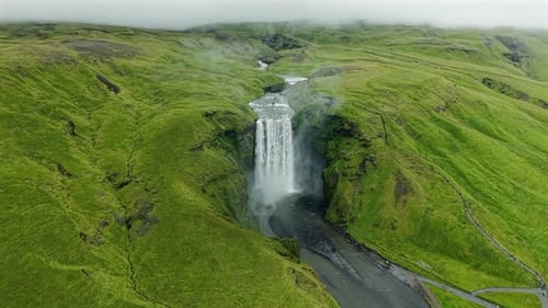 Hoher Wasserfall, umgeben von üppigen grünen Hügeln