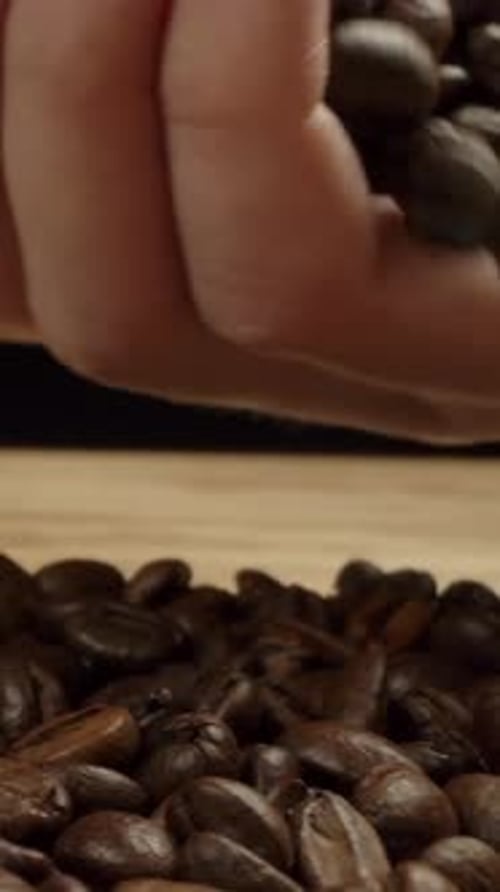 Pouring Coffee Beans on Pile Close Up