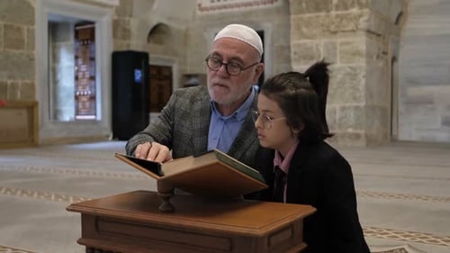 Grandfather Reads from Holy Book with Child in Mosque