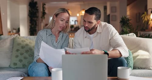 Man and Woman Reviewing Documents on Couch