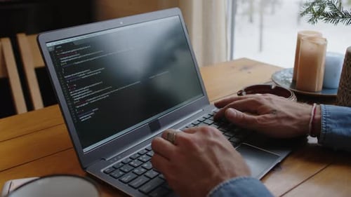 Faceless Programmer Deleting Code and Typing Again on Laptop Indoors