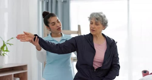 Woman Helping Senior with Arm Stretching Exercises at Home
