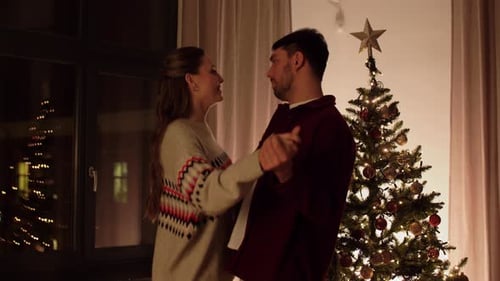Winter Holidays and People Concept - Happy Couple Dancing Near Christmas Tree