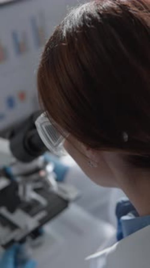 Medical Professional Using Microscope in Laboratory
