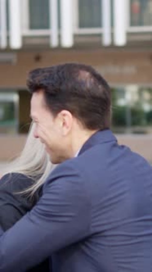 Business People Shaking Hands and Hugging in City