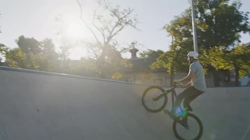 Young Adult Biking on Ramp in Skate Park