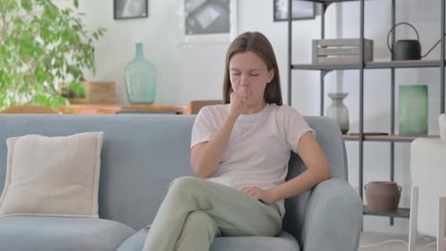 Woman Coughing on a Couch Indoors