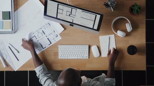 Architect Working on Floor Plans at Desk