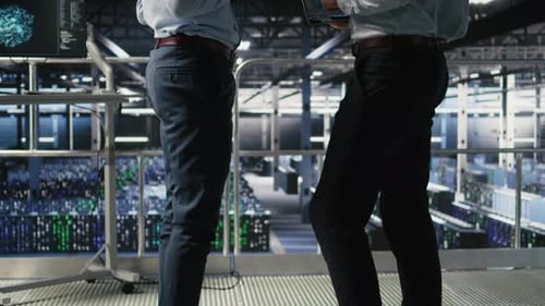 Data Center Team Leader and Worker Reviewing Performance Dashboards of AI