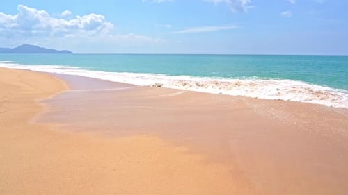 Beautiful shot of waves crashing on golden beach. Slow-motion