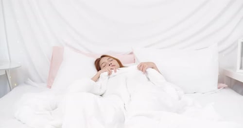 Calm young woman sleeping well in comfortable cozy fresh bed on soft pillow white linen orthopedic m