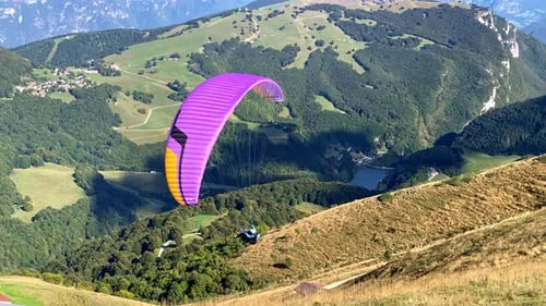 Paraglider take off and flying above mountains