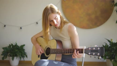 Woman Plays Acoustic Guitar in Sunny Room