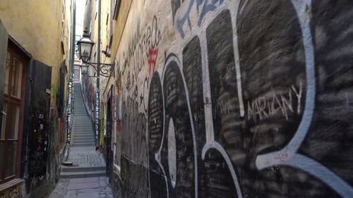 Pan view of old historic street. Murals art on the colorful wall. Narrow alley in old town. Warm lig