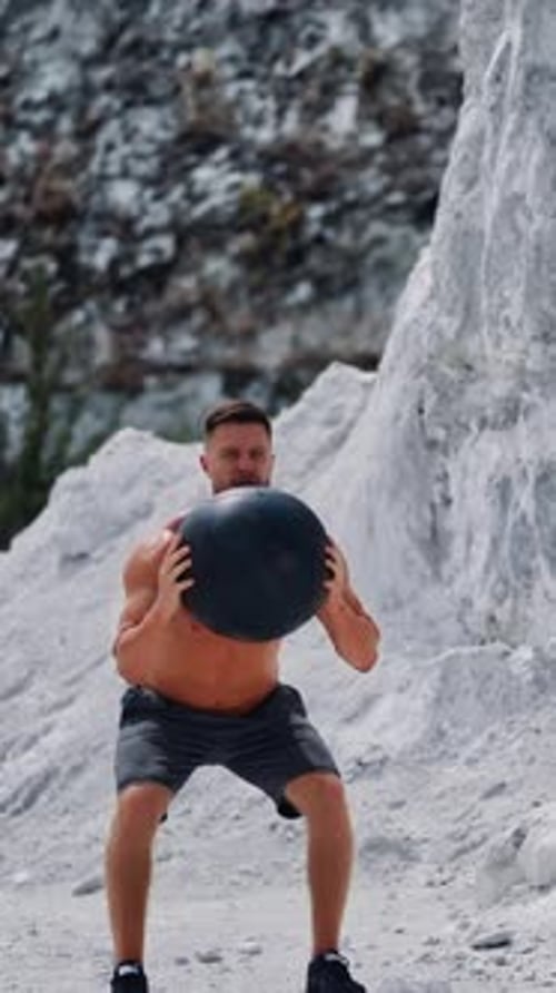 Strong Man Exercising With Medicine Ball Outdoors