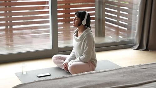 Woman Meditates on Yoga Mat Drinking Water