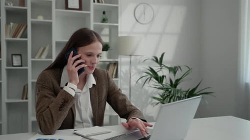 Modern Lady Works Online From Home on a Computer and Answers Phone Calls