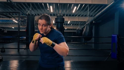 Muscular Woman Boxing in Gym