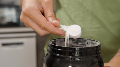 Adult Opens Jar of Protein Powder for Fitness