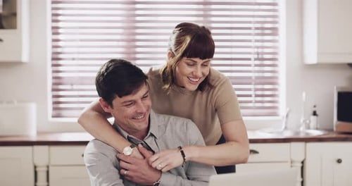 Loving Couple Using Laptop Together in Kitchen