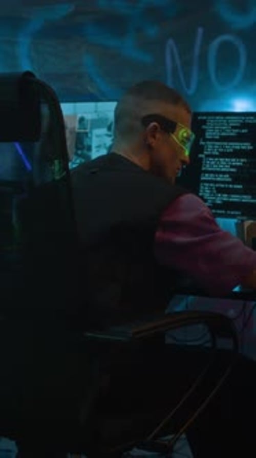 Man Coding in Dark Room with Futuristic Glasses