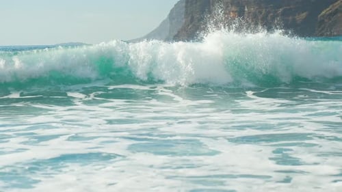 Tracking follow shot of strong powerful shorebreak waves crashing and rolling to beach