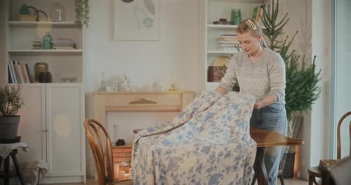Woman Putting Tablecloth While Setting Table