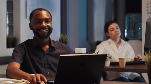 Portrait d'un gestionnaire heureux et prospère assis au bureau la nuit