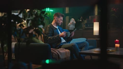 Man Using Tablet Relaxing at Home at Night