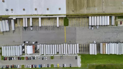 Blick aus der Vogelperspektive auf ein großes Kommerziell Versandzentrum mit vielen Güterwagen, die entladen und hochladen