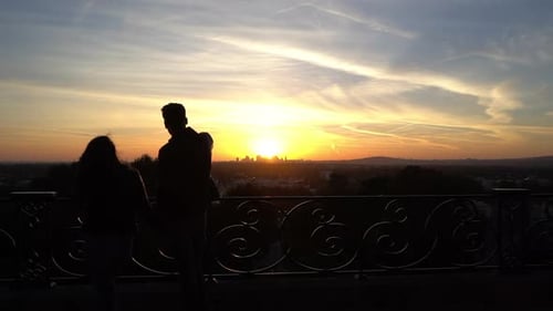 Silueta de pareja joven mira el paisaje al amanecer