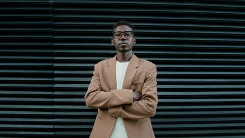 Stylish Man Posing Confidently in Front of Wall