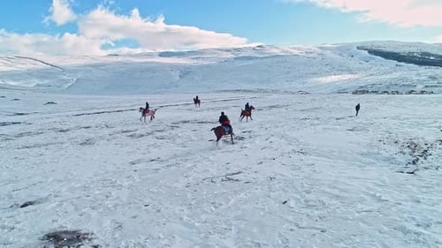 Horseback Riders in Snowy Mountain Landscape