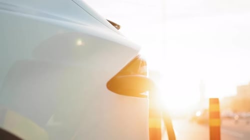 Elektroauto mit Steckerkabel, das an den Ladeanschluss der EV-Station im Freien angeschlossen ist