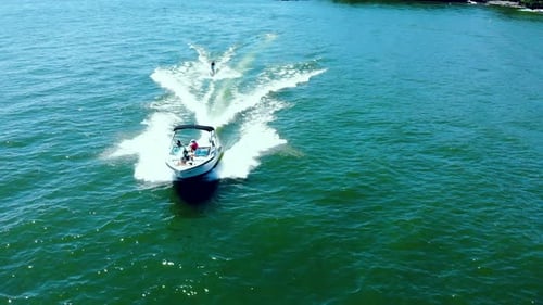 Aerial view of high speed motor boat pulling a water-skier.