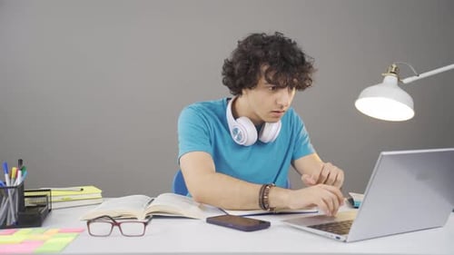 Excited Student Celebrating Success at Desk With Laptop