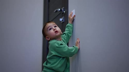 Infant Interacting with Light Switch Indoors