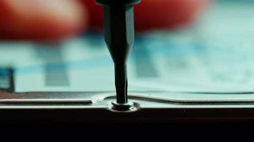 Screwdriver Turns Screw on Computer Hard Drive