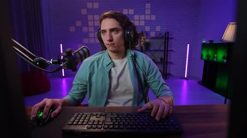 Young Adult Typing at Computer with Microphone On