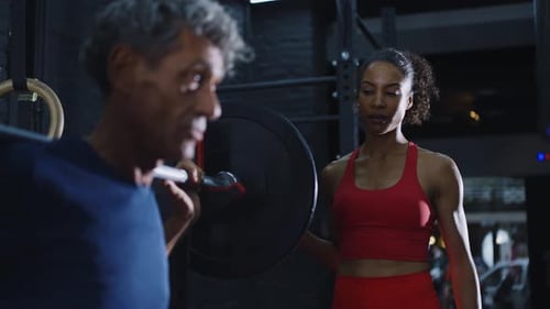 senior man training in the gym with his coach and personal trainer.